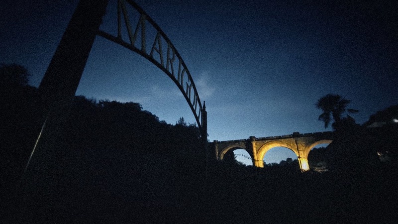 The Marigold arch at night, with the floodlit viaduct beyond